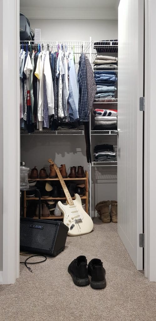 A guitar and an amplifier inside a closet.