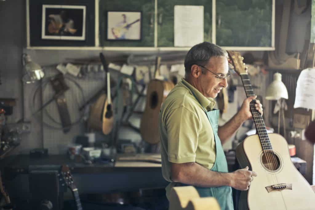A luthier holding a guitar.