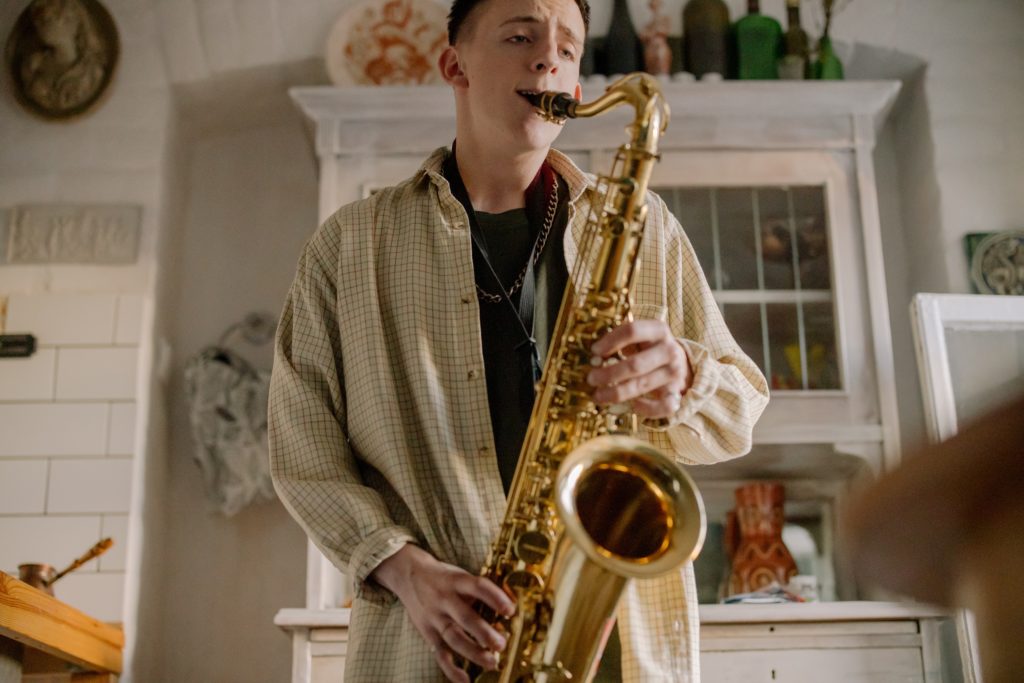 A man playing an expensive alto saxophone