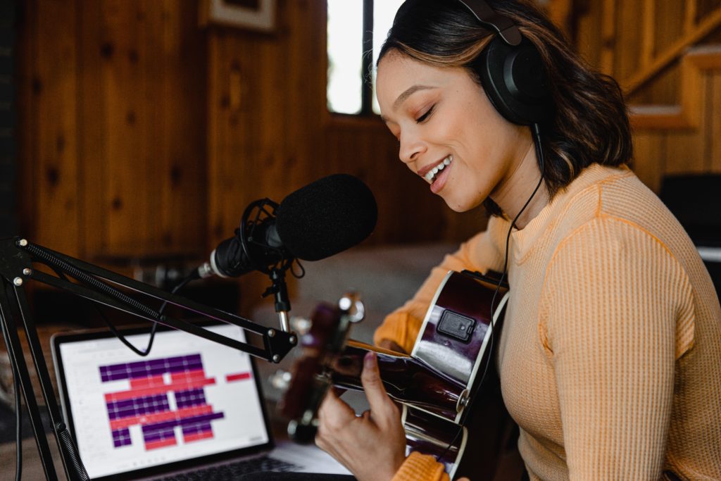 A woman recording a guitar at home studio.