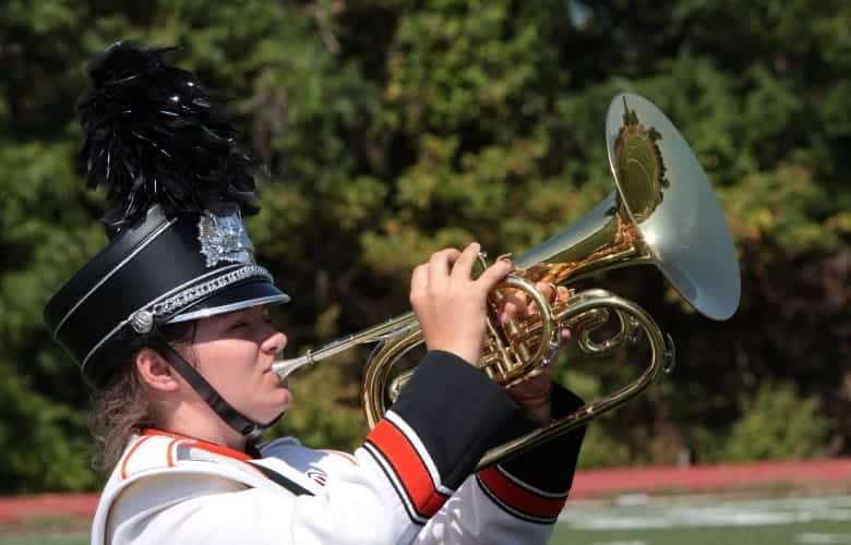 Marching band student playing a Mellophone