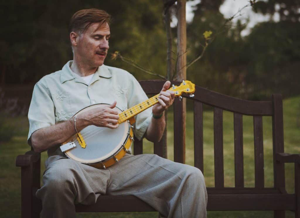 Playing a  banjo ukulele at the backyard