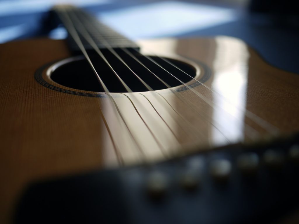 A close up picture of a 6-string acoustic guitar