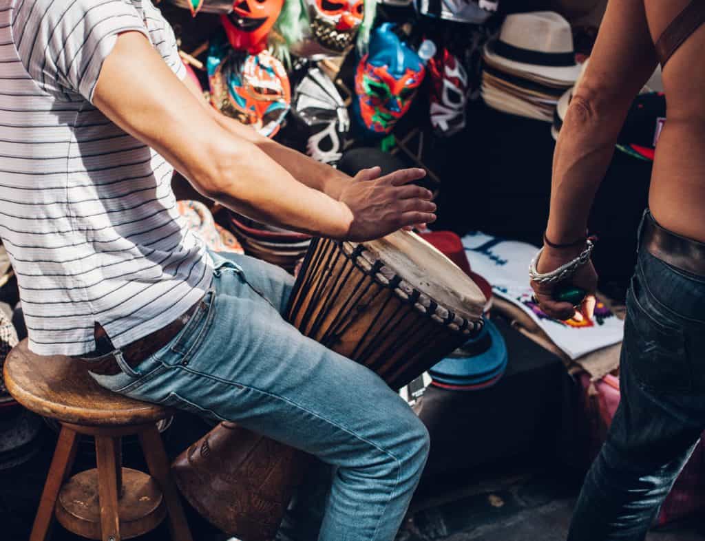 A performer playing a bongo in the street
