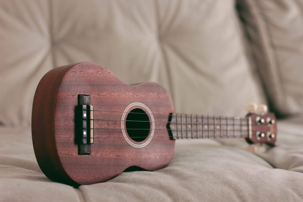 brown ukulele on a couch