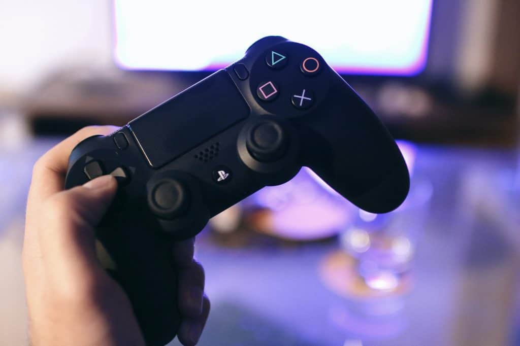 A close up of a hand holding a Ps4 Controller