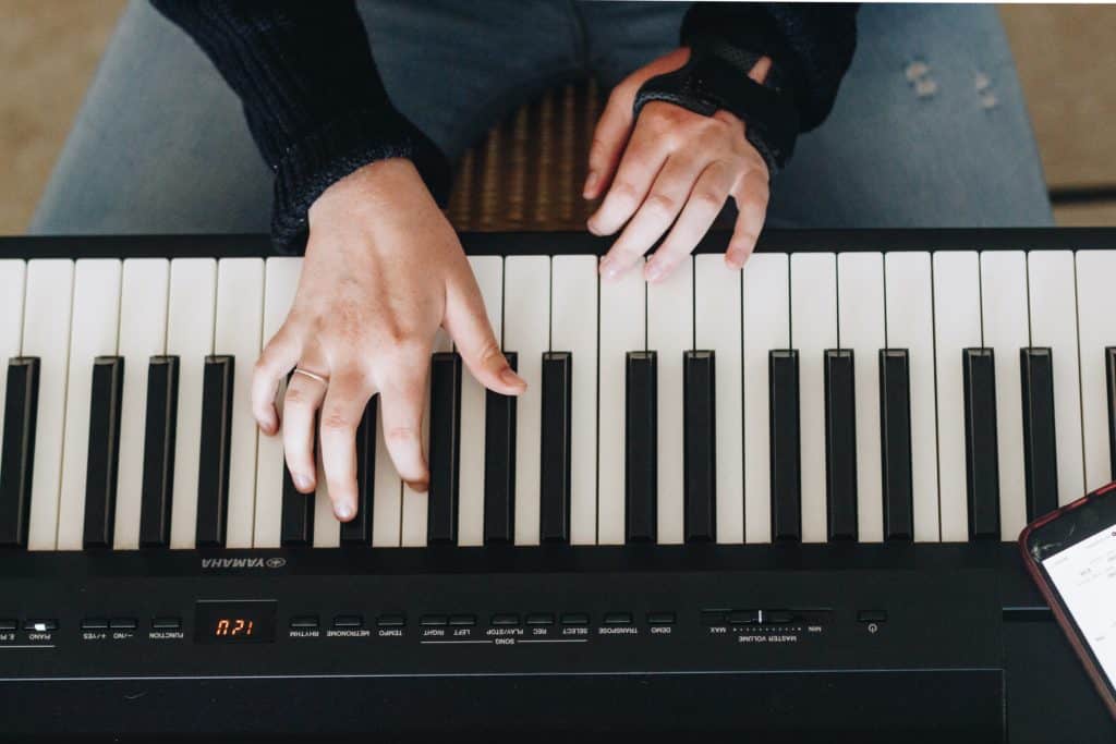 A close-up of a woman's hands as she learns to play the piano