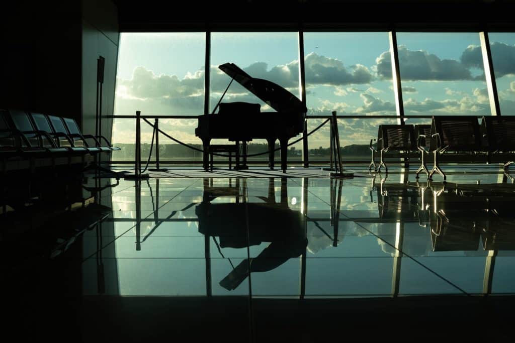A sillhouette of grand piano inside the building