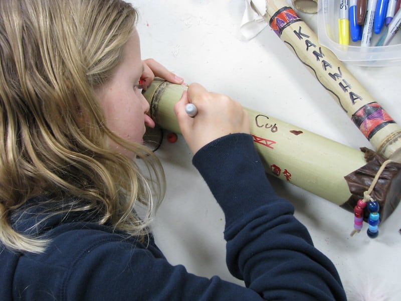 Little girl making a rain stick