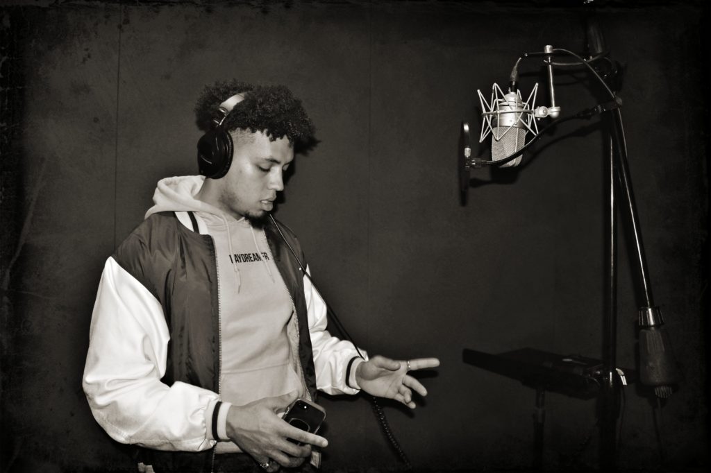Grayscale photo of a rapper recording in the studio