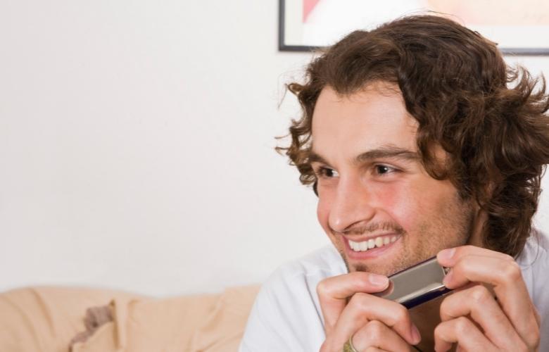 Happy man playing a harmonica