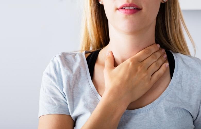 Woman holding her neck area to relax her throat